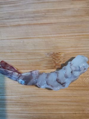 Pulire i gamberi (togliere la testa, togliere la pelle e lasciare la coda lunga circa 2 cm, quindi tagliare il dorso), lavarli e asciugarli con un fazzoletto di carta.