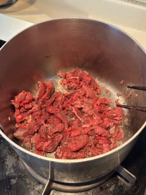 將醃製好的牛肉翻炒至九成熟。