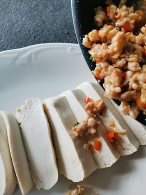 Dann das gekochte Hühnchen über den Tofu geben