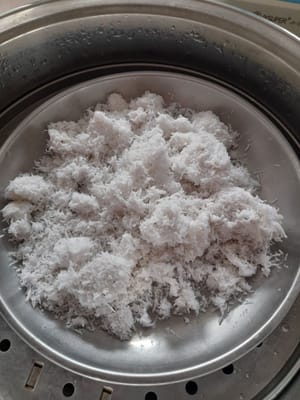 すりおろしたココナッツを 15 分間蒸し、蓋をして火から下ろし、置いておきます。