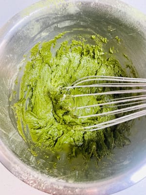 混ぜ合わせたケーキ粉と抹茶パウダーをふるい入れ、ヘラでZ字を描くように混ぜます（円を描くように混ぜないでください。円を描くように混ぜると小麦粉にグルテンができ、ケーキが固くなります）。