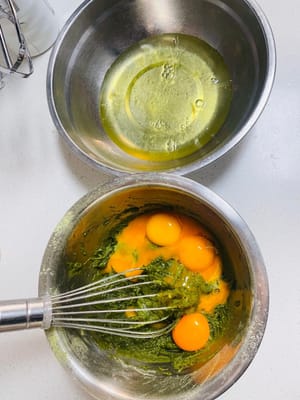 まず、卵黄と卵白を完全に分けます（卵白は別の、乾いた、油分のないボウルに入れます）。卵黄を抹茶パウダーに加え、Z字を描くように優しく混ぜて、卵黄が均一になるまで混ぜます（動画をご覧ください）。卵黄生地は滑らかで、粉っぽさが残っていない状態です。置いておきます。（オーブンを上下2段加熱し、150℃に予熱します。）