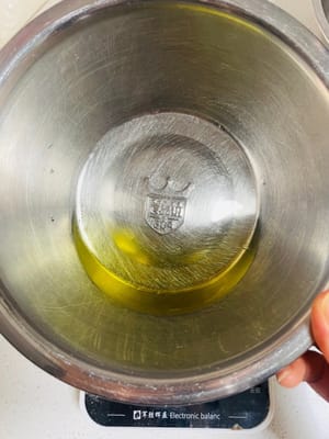 卵黄を入れたボウルにコーン油、牛乳、砂糖 20g を注ぎ、砂糖が溶けるまでかき混ぜます。