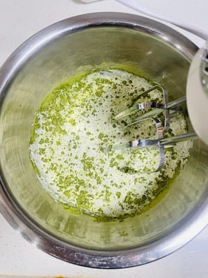 クリームフィリングを作る
夏場はエアコンをつけてクリームを泡立てるのを忘れないようにしてください。室温が高すぎるとクリームが溶けやすく、うまく泡立てられません（室温は20℃を超えないようにしてください）。生クリームに抹茶パウダー6gと砂糖20gを加え、手で数回かき混ぜてよく混ぜ合わせ、電動ミキサーで泡立てます。クリームが7割程度泡立つまで泡立て、その後低速に切り替え（泡立てすぎを防ぐため）、クリームがまっすぐ立つ程度（9割程度）になったら泡立てを止めます。泡立てすぎに注意してください（泡立てすぎるとバター状になり、使えなくなります）。