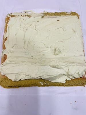 ケーキの巻き方と成形

1. 作業台にクッキングシートを敷き、フロスティング面を上にします。ケーキの両端を斜めに切り落とします（こうすることで、ケーキを巻く際に形が崩れにくくなり、見た目も良くなります）。中央に浅く数カ所切り込みを入れます（完全に切り込まないでください！ こうすることで、ケーキを曲げやすくなり、割れるのを防ぎます）。

2. フロスティングを塗ります。手前に来る面は厚く塗ります（こうすることで、中央がふっくらとして、巻いた時に空洞になるのを防ぎます）。

3. （動画参照）麺棒で押さえながら、ケーキを素早く巻き上げます。ケーキローラーがない場合は、使用してください。クッキングシートは少し幅広にしておくと、端をクリップで留めやすくなります。冷蔵庫で少なくとも3時間冷やします（こうすることで、ケーキを切った時に崩れにくくなり、きれいに切れます）。