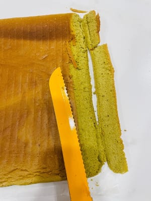 ケーキの巻き方と成形

1. 作業台にクッキングシートを敷き、フロスティング面を上にします。ケーキの両端を斜めに切り落とします（こうすることで、ケーキを巻く際に形が崩れにくくなり、見た目も良くなります）。中央に浅く数カ所切り込みを入れます（完全に切り込まないでください！ こうすることで、ケーキを曲げやすくなり、割れるのを防ぎます）。

2. フロスティングを塗ります。手前に来る面は厚く塗ります（こうすることで、中央がふっくらとして、巻いた時に空洞になるのを防ぎます）。

3. （動画参照）麺棒で押さえながら、ケーキを素早く巻き上げます。ケーキローラーがない場合は、使用してください。クッキングシートは少し幅広にしておくと、端をクリップで留めやすくなります。冷蔵庫で少なくとも3時間冷やします（こうすることで、ケーキを切った時に崩れにくくなり、きれいに切れます）。