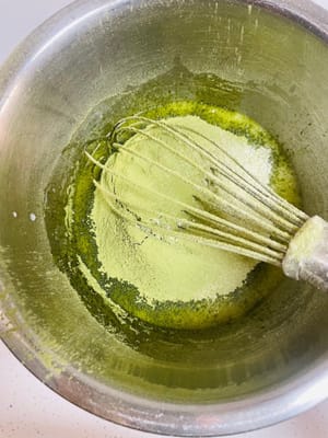 混ぜ合わせたケーキ粉と抹茶パウダーをふるい入れ、ヘラでZ字を描くように混ぜます（円を描くように混ぜないでください。円を描くように混ぜると小麦粉にグルテンができ、ケーキが固くなります）。
