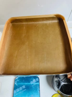 天板にクッキングシートを敷きます。天板にクッキングシートを敷くことで、滑らかでタオルのような表面を実現できます。28×28cmの天板はロールケーキを作るのに最適で、ちょうど良い厚さのケーキが作れます。