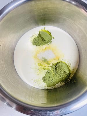 クリームフィリングを作る
夏場はエアコンをつけてクリームを泡立てるのを忘れないようにしてください。室温が高すぎるとクリームが溶けやすく、うまく泡立てられません（室温は20℃を超えないようにしてください）。生クリームに抹茶パウダー6gと砂糖20gを加え、手で数回かき混ぜてよく混ぜ合わせ、電動ミキサーで泡立てます。クリームが7割程度泡立つまで泡立て、その後低速に切り替え（泡立てすぎを防ぐため）、クリームがまっすぐ立つ程度（9割程度）になったら泡立てを止めます。泡立てすぎに注意してください（泡立てすぎるとバター状になり、使えなくなります）。