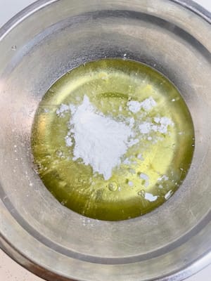 卵白のボウルにレモン汁を数滴加えます（魚臭さを取り除き、卵白を安定させます）。次に、コーンスターチ10gを加えます。卵白を泡立てる際に粉が飛び散らないように、手で数回かき混ぜます。