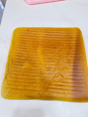 ケーキの巻き方と成形

1. 作業台にクッキングシートを敷き、フロスティング面を上にします。ケーキの両端を斜めに切り落とします（こうすることで、ケーキを巻く際に形が崩れにくくなり、見た目も良くなります）。中央に浅く数カ所切り込みを入れます（完全に切り込まないでください！ こうすることで、ケーキを曲げやすくなり、割れるのを防ぎます）。

2. フロスティングを塗ります。手前に来る面は厚く塗ります（こうすることで、中央がふっくらとして、巻いた時に空洞になるのを防ぎます）。

3. （動画参照）麺棒で押さえながら、ケーキを素早く巻き上げます。ケーキローラーがない場合は、使用してください。クッキングシートは少し幅広にしておくと、端をクリップで留めやすくなります。冷蔵庫で少なくとも3時間冷やします（こうすることで、ケーキを切った時に崩れにくくなり、きれいに切れます）。