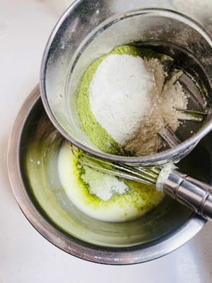 混ぜ合わせたケーキ粉と抹茶パウダーをふるい入れ、ヘラでZ字を描くように混ぜます（円を描くように混ぜないでください。円を描くように混ぜると小麦粉にグルテンができ、ケーキが固くなります）。