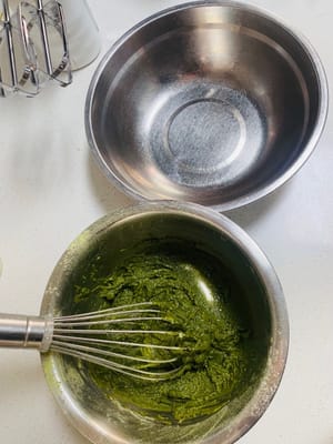 まず、卵黄と卵白を完全に分けます（卵白は別の、乾いた、油分のないボウルに入れます）。卵黄を抹茶パウダーに加え、Z字を描くように優しく混ぜて、卵黄が均一になるまで混ぜます（動画をご覧ください）。卵黄生地は滑らかで、粉っぽさが残っていない状態です。置いておきます。（オーブンを上下2段加熱し、150℃に予熱します。）