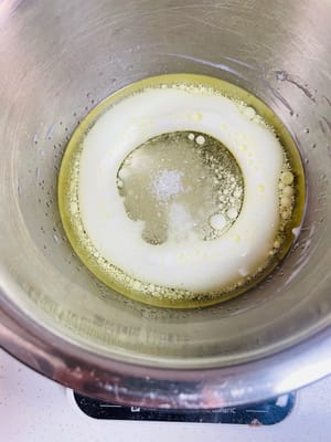 卵黄を入れたボウルにコーン油、牛乳、砂糖 20g を注ぎ、砂糖が溶けるまでかき混ぜます。