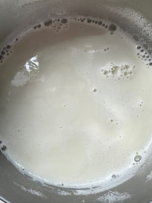 aggiungere acqua tiepida al sacchetto del latte di soia in questo momento. L'acqua tiepida facilita la preparazione del latte di soia. A questo punto, aggiungere acqua in base alle proprie preferenze personali per quanto riguarda la concentrazione del latte di soia.