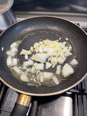 中華鍋がまだ熱いうちに玉ねぎとニンニクを加え、強火で炒めます。