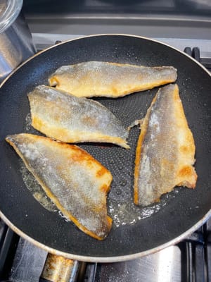 魚の切り身の両面がきつね色になって焼けたら、火を止めて魚を脇に置きます。