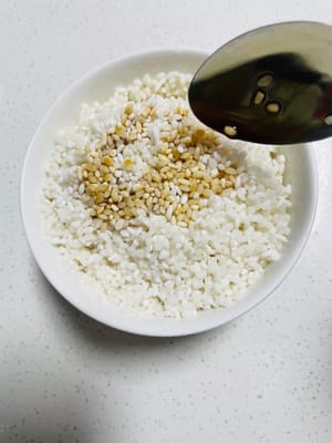 Arroz glutinoso marinado: Lavar y escurrir, añadir 1 cucharada de salsa de soja clara y 1 cucharada de salsa de soja oscura y dejar marinar unos minutos.