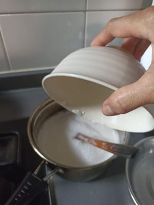 将木薯粉和米粉液体放入装有椰奶的锅中。