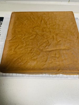Line the baking rack with high-temperature baking paper, take out the cake and shake it (to shake out the hot air), quickly turn it upside down on the baking paper, tear off the baking paper while it is still hot, cover it with baking paper and let it cool for later use.