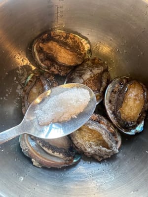 首先清洗鮑魚。用鹽搓揉鮑魚，浸泡在溫水中10分鐘，然後沖洗乾淨。