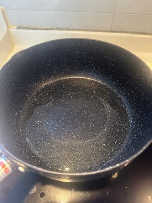 在加熱的平底鍋中倒入油，放入紅蔥頭、薑和蒜，翻炒至略呈褐色。