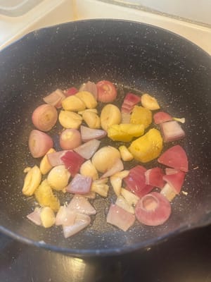 在加熱的平底鍋中倒入油，放入紅蔥頭、薑和蒜，翻炒至略呈褐色。