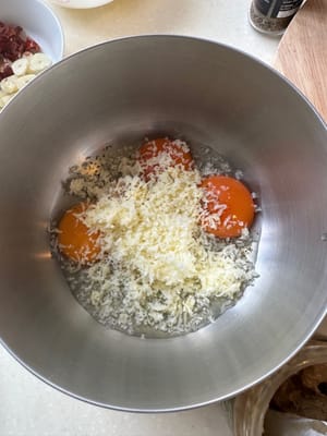 Comienza preparando la salsa para pasta. En un tazón grande, mezcla los huevos, la pimienta negra, el queso rallado y la mantequilla de pistacho hasta que estén bien integrados.