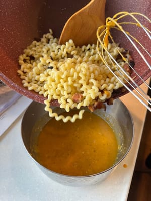Luego, transfiera la pasta al tazón con la salsa, mezcle bien mientras esté caliente.