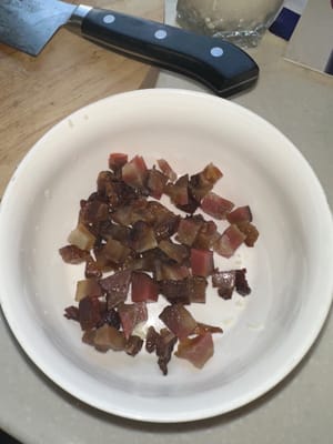 Picar el tocino de Sichuan y freírlo en una sartén a fuego lento para que suelte su aceite.