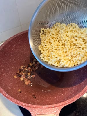 Apagar el fuego, echar la pasta para que quede cubierta con el aceite de tocino.