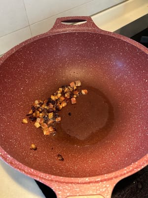 Picar el tocino de Sichuan y freírlo en una sartén a fuego lento para que suelte su aceite.