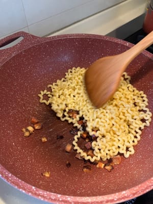 Apagar el fuego, echar la pasta para que quede cubierta con el aceite de tocino.