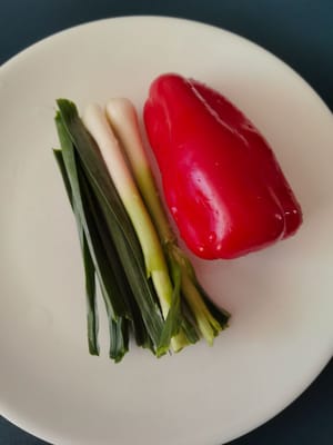 Zwei Knoblauchsprossen und eine rote Paprika