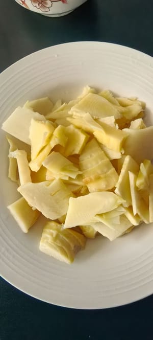 Wasser in einem Topf zum Kochen bringen, geschnittene Winterbambussprossen und etwas Salz hinzufügen, drei Minuten blanchieren, dann mit klarem Wasser abspülen und abtropfen lassen.