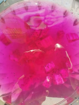 Pour the cooked dragon fruit peel water into a large bowl. Add two spoons of sugar. Add dragon fruit pulp. Stir well.