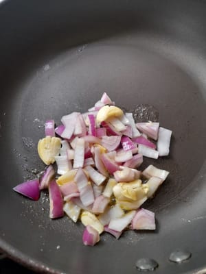 Eine Bratpfanne vorbereiten, Margarine hineingeben, warten bis sie heiß ist, dann Zwiebel und Knoblauch dazugeben, anbraten bis sie welk sind (duftend)