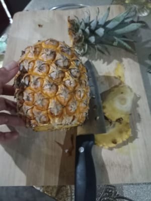 Épluchez l'ananas et coupez-le en quatre morceaux. Ensuite, coupez-le en petits morceaux.
