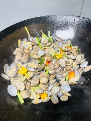 Heat a wok over medium-low heat. Add ginger, onion, scallion whites, and celery. Sauté until fragrant. Then, add bell peppers (chili peppers), minced garlic, and fermented black beans. Stir-fry until fragrant. Add clams and stir-fry quickly and evenly to coat them with the base.