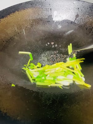 Heat a wok over medium-low heat. Add ginger, onion, scallion whites, and celery. Sauté until fragrant. Then, add bell peppers (chili peppers), minced garlic, and fermented black beans. Stir-fry until fragrant. Add clams and stir-fry quickly and evenly to coat them with the base.