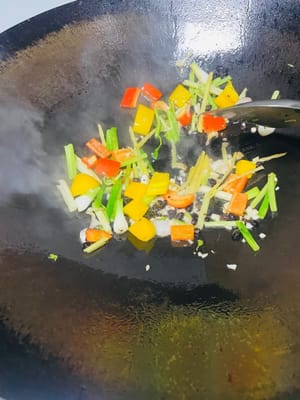 Heat a wok over medium-low heat. Add ginger, onion, scallion whites, and celery. Sauté until fragrant. Then, add bell peppers (chili peppers), minced garlic, and fermented black beans. Stir-fry until fragrant. Add clams and stir-fry quickly and evenly to coat them with the base.