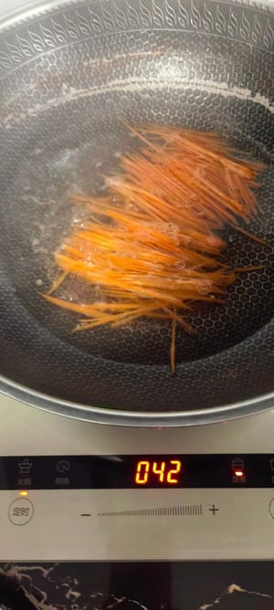 Tritare le carote, sbollentarle brevemente in acqua bollente e metterle da parte. Il cetriolo non ha bisogno di essere sbollentato.