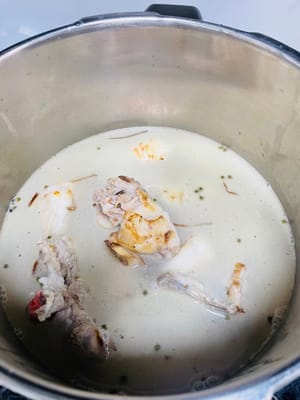 Placer les os d’agneau rôtis, la racine d’angélique, le gingembre, les coques de poivre vert du Sichuan et les écorces de mandarine séchées dans une cocotte-minute. Ajouter une grande quantité d’eau chaude. Couvrir et laisser bouillir 4 minutes. Éteindre le feu et laisser retomber la pression naturellement. Dans une cocotte classique, cuire environ 30 minutes.