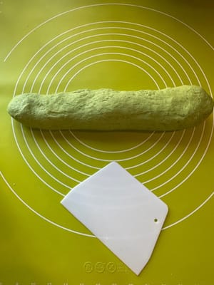 生地を細長く伸ばし、さらに9つの小さな生地に切り分けます。乾燥を防ぐため、ラップで覆います。