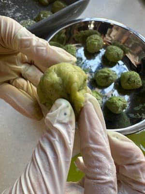 次に、クリームチーズボールを餅の上に取り、ボール状に包みます