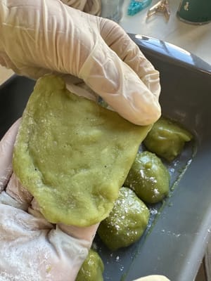 まず、両手に小麦粉を少しつけ、餅を薄く伸ばします。