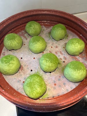 生地を蒸し器に入れ、発酵させます。生地に抹茶を振りかけて飾ります。