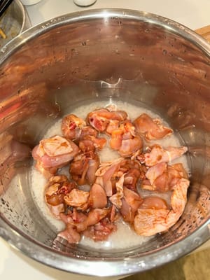 Déposer le poulet mariné sur le riz. Laisser cuire au cuiseur à riz.