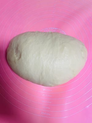 空気を抜く + 分割：生地をほぐす
発酵した生地を取り出し、ボール状に丸めて空気を抜き、15分間休ませます（この間に休憩を取り、水を飲んでも構いません）。
28×28cmの天板を使用する場合は、生地を25等分（1個あたり約35g）に分けます。より大きなパンを作りたい場合は、サイズを調整してください。