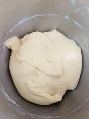 一次発酵：生地がふっくらするまで待ちます
こねた生地を容器に入れ、ラップで包み、温かい場所で2倍の大きさになるまで発酵させます。
見分け方：濡れた指で小さなへこみを突いた時に、へこみが元に戻ったり縮んだりしなければ、発酵完了です（生地：「発酵完了～」）。